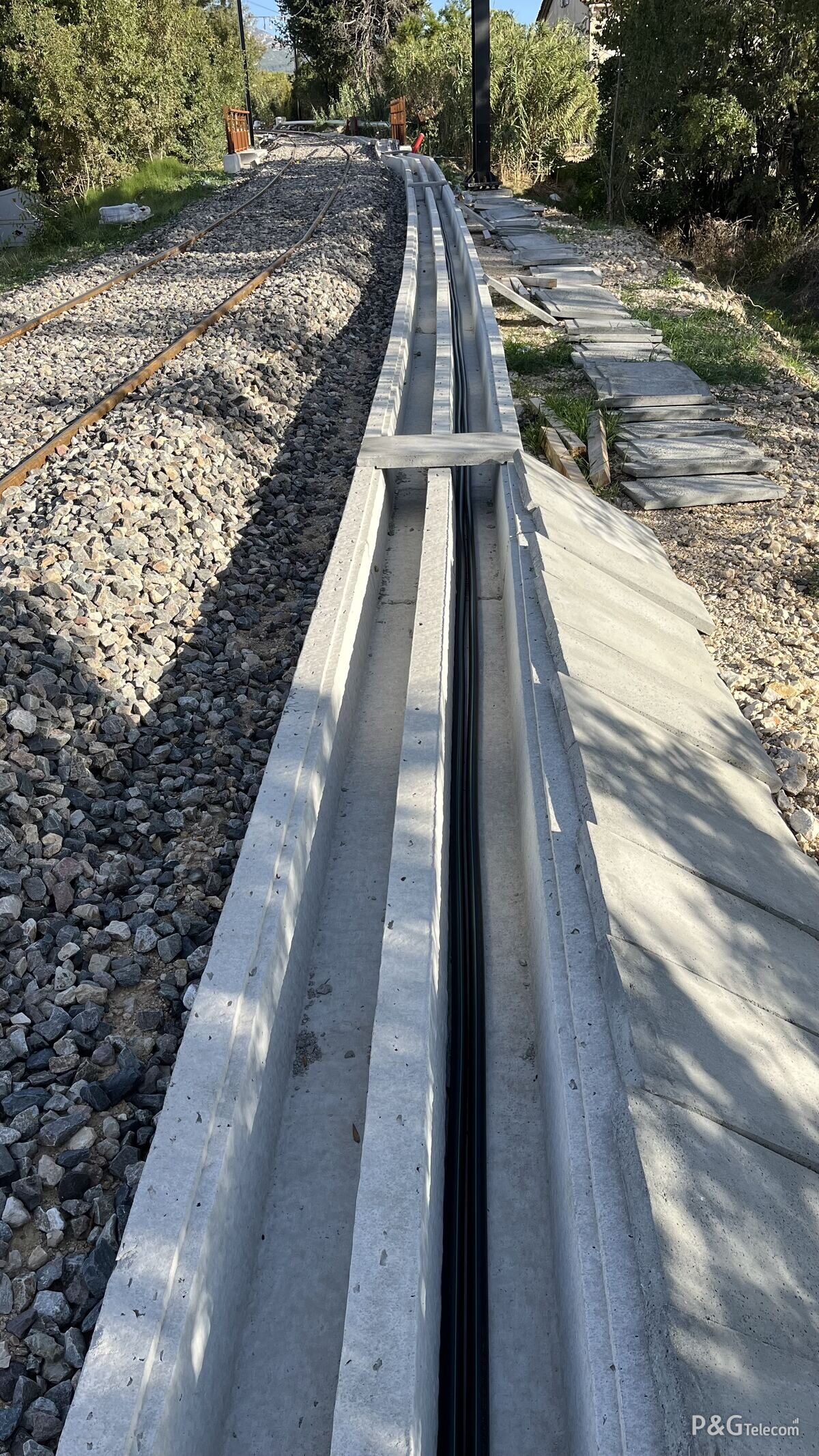 Caniveau béton et déroulé fibre le long de la voie tramway, chantier P&G Telecom